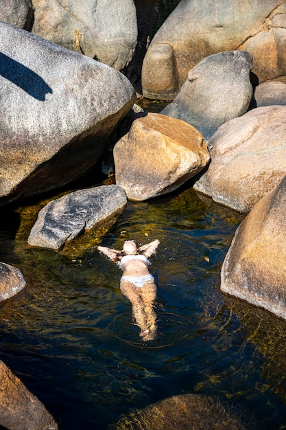 piękna dziewczyna w białym bikini leży na wodzie w naturalnym basenie w Jourama Falls, australia