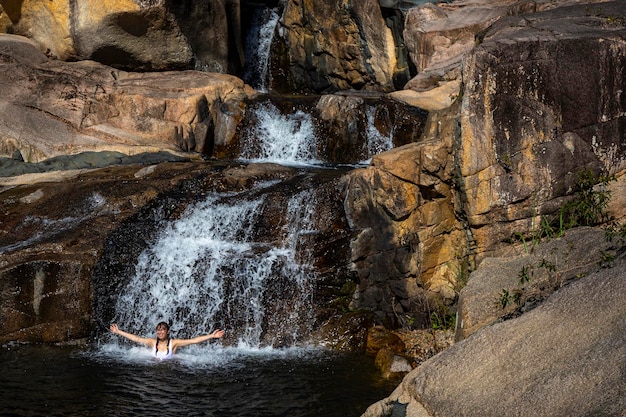 piękna dziewczyna w białym bikini pływa w naturalnym basenie w Jourama Falls, Queensland, Australia