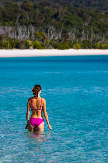 Piękna dziewczyna w bikini cieszy się kąpielą w turkusowej wodzie na plaży Whitehaven, australia