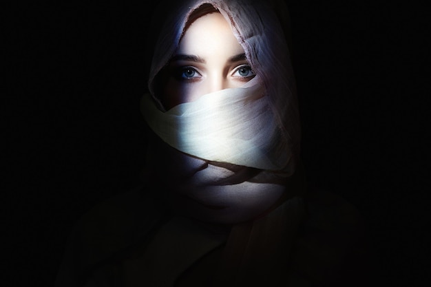 Piękna dziewczyna w hidżabie patrząc od ciemnej piękności w kapturze