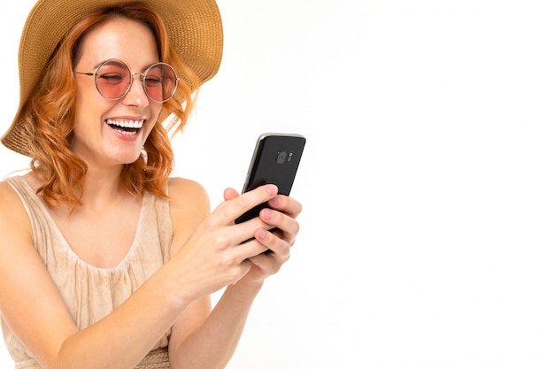 Piękna dziewczyna w lato kapeluszu i okularach przeciwsłonecznych bierze selfie na bielu z kopii przestrzenią