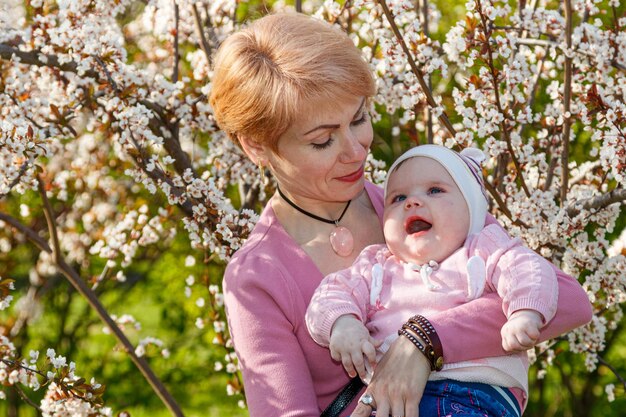 Zdjęcie piękna dziewczyna w ramionach dziewczynki w kwitnącym parku