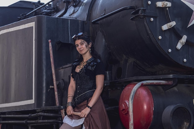 Piękna dziewczyna w steampunkowych ubraniach na tle pociągu