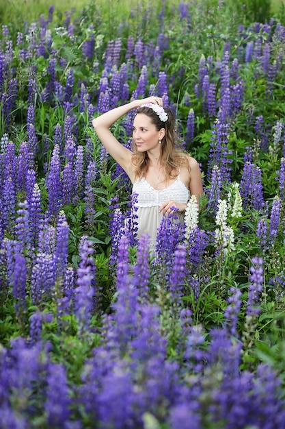 Piękna dziewczyna z bukietem niebieskich kwiatów na naturze latem