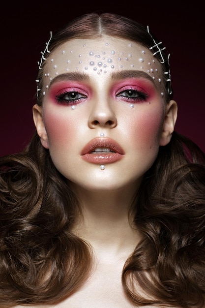 Zdjęcie piękna dziewczyna z doskonałym makijażem artystycznym i perłowymi koralikami piękna twarz