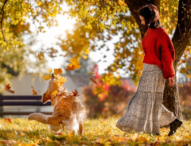 Piękna dziewczyna z golden retriever psem w jesiennym parku