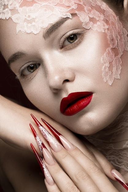Piękna dziewczyna z koronkowymi czerwonymi ustami i długimi paznokciami Piękna twarz Zdjęcia zrobione w studio