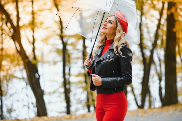 Piękna dziewczyna z parasolem w jesień parku.