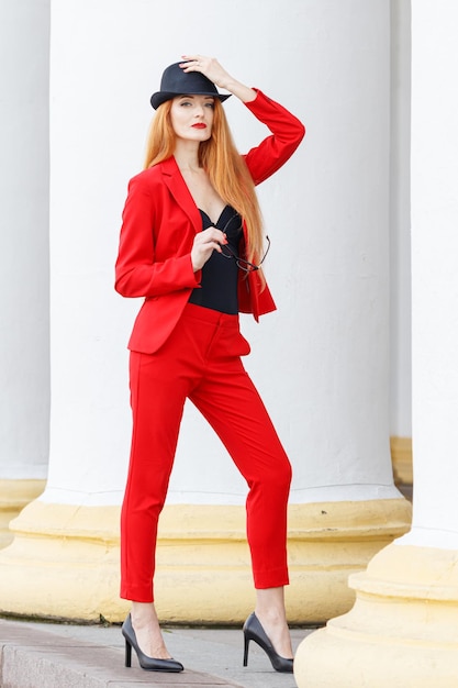Piękna dziewczyna z rudymi włosami ubrana w czerwony garnitur Biznesowy portret