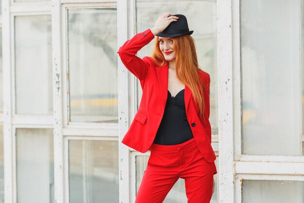 Piękna dziewczyna z rudymi włosami ubrana w czerwony garnitur Biznesowy portret