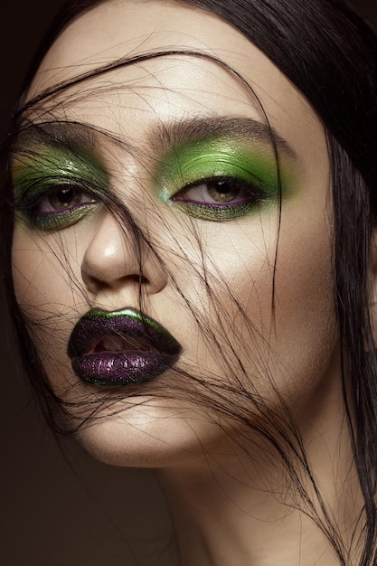 Piękna dziewczyna z wiosennym zielonym makijażem i twarzą urody wampira