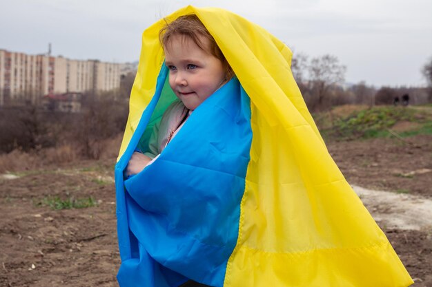 Piękna dziewczynka z flagą Ukrainy na tle miasta i jeziora w ukraińskim mieście Portret patriotycznej dziewczynki z flagą Ukrainy