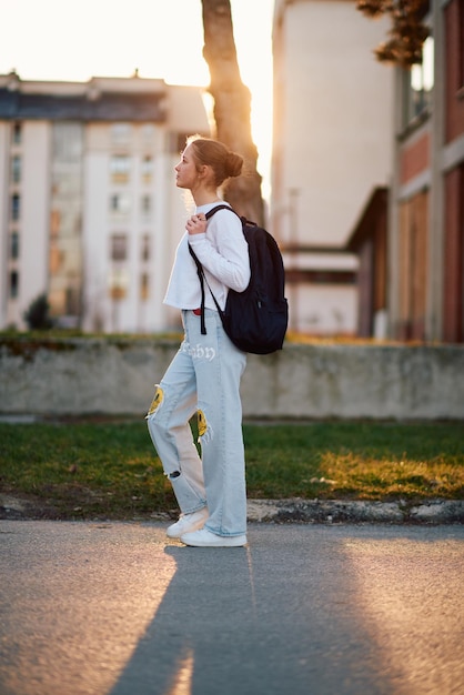 Piękna europejska nastolatka uchwycona w portretie bocznym idzie do domu podczas zachodu słońca po