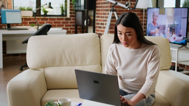 Piękna Freelancerka Wykonująca Pracę Zdalną Na Nowoczesnym Laptopie Podczas Rozwijania Pomysłów Biznesowych W Domu. Pospiesznie Młoda Dorosła Kobieta Pracująca Zdalnie Nad Projektem Startowym Z Powodu Przedwczesnego Terminu.