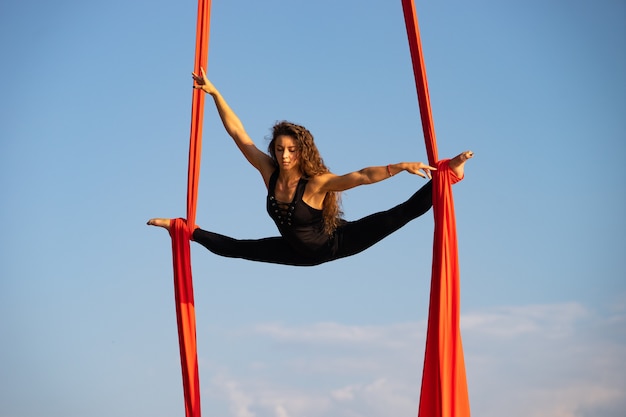Piękna i elastyczna artystka cyrkowa tańcząca z powietrznym jedwabiem