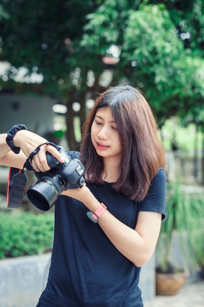Piękna i Szczęśliwa Azjatycka kobiety mienia kamera w ogródzie.