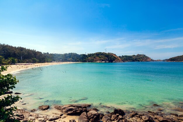 Piękna, jasna plaża nai harn w Tajlandii na wyspie Phuket z czystą, turkusową wodą w morzu, białym piaskiem i niebieskim niebem.