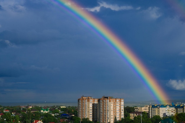 piękna jasna tęcza nad miastem. Zdjęcie wysokiej jakości