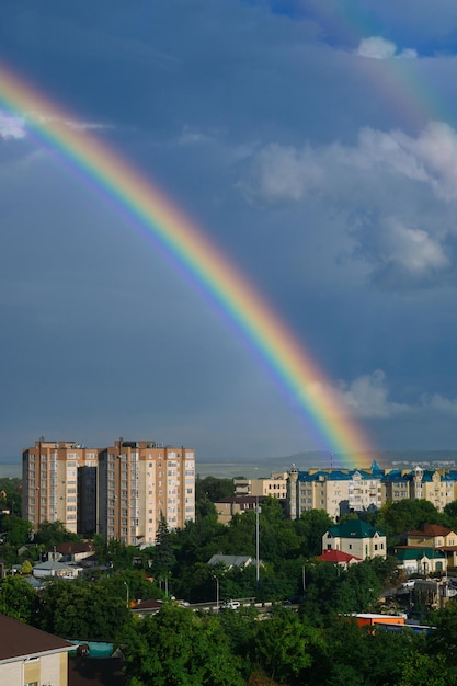 piękna jasna tęcza nad miastem. Zdjęcie wysokiej jakości