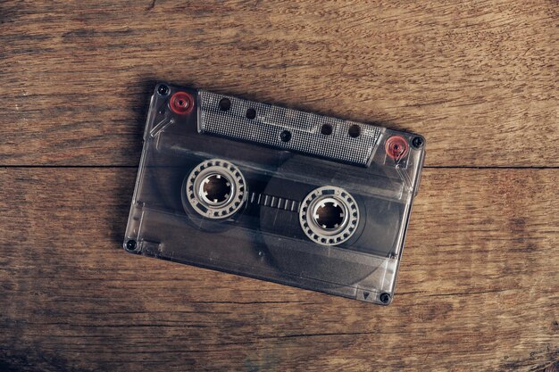 Piękna kaseta audio na brązowym starym drewnianym stole Minimalizm w stylu retro koncepcja lat osiemdziesiątych