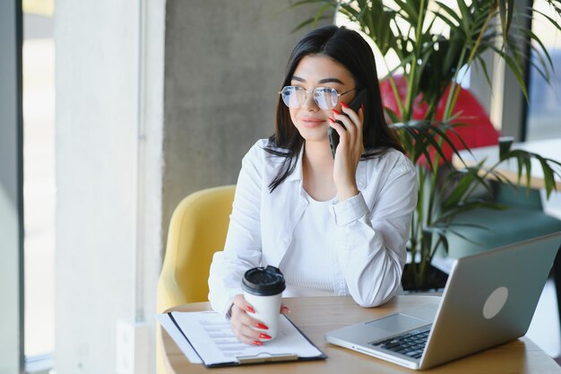 Piękna kaukaska kobieta marzy o czymś siedząc z przenośnym netbookiem w nowoczesnej kawiarni bar młody uroczy freelancer myśli o nowych pomysłach podczas pracy na komputerze przenośnym