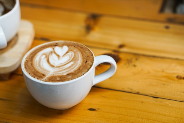 Piękna kawa latte art z piankowym mlecznym drzewnym obrazkiem