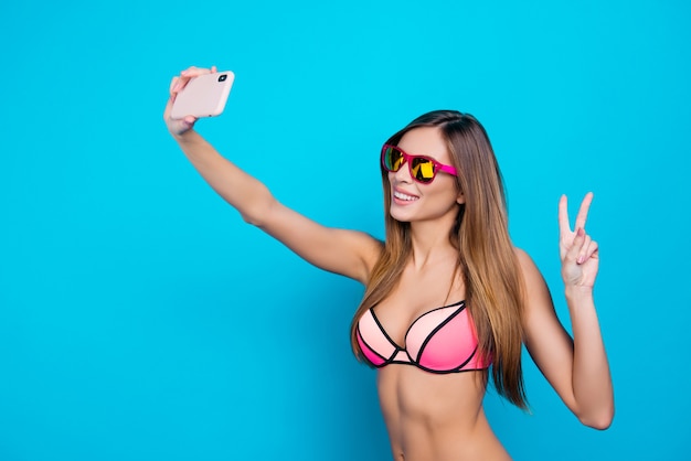 Piękna kobieta, biorąc selfie w bikini z smartphone