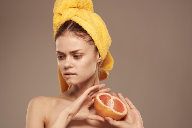 Zdjęcie piękna kobieta goła ramiona grejpfrut w ręku naturalne kosmetyki witaminy wysokiej jakości zdjęcie