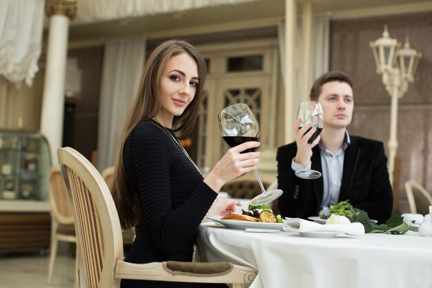 Piękna kobieta i mężczyzna w restauracji, trzymając kieliszek wina