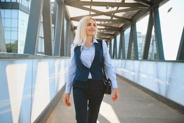 Piękna kobieta idąca do pracy Biznesowa kobieta spacerująca w pobliżu biurowca Portret kobiety odnoszącej sukcesy w biznesie