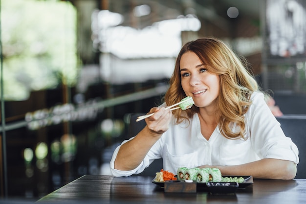 Piękna kobieta jedzenie sushi