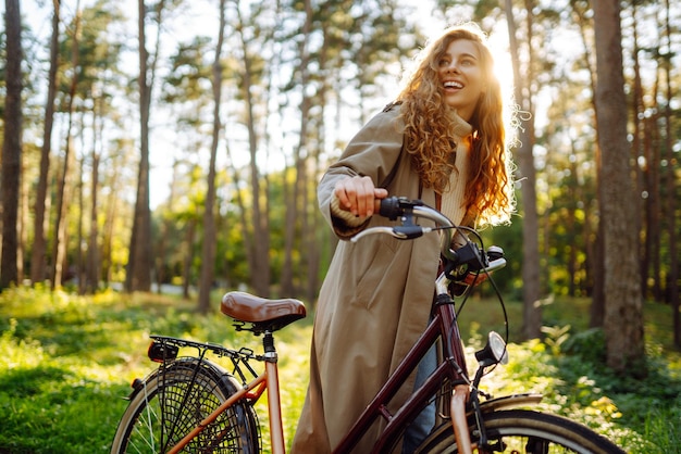 Zdjęcie piękna kobieta jeżdżąca rowerem w parku styl życia zrelaksować się koncepcja przyrody wiosna