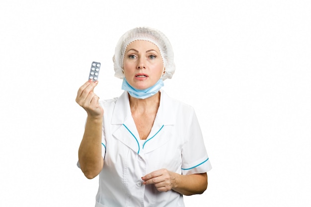 Piękna kobieta lekarz pokazuje pigułki. dojrzała kobieta lekarz przepisując leki i dając blister tabletek stojących na białym tle.