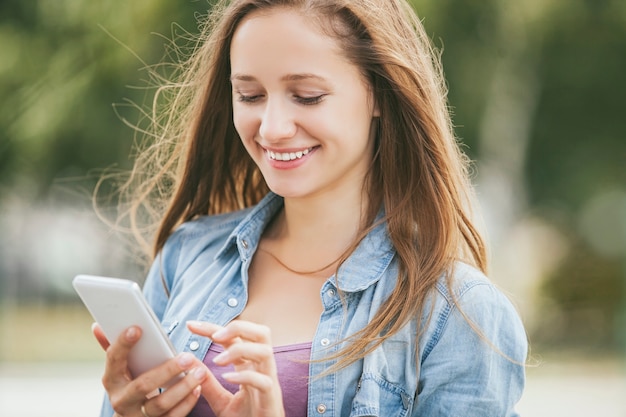 Piękna kobieta model z telefonem komórkowym na zewnątrz