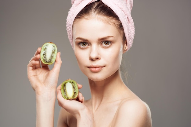 Piękna kobieta nagie ramiona zabiegi spa kiwi w dłoniach kosmetyki naturalne