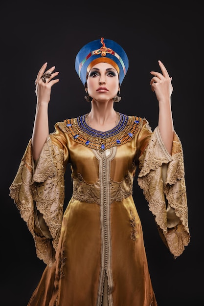 Piękna kobieta o brązowych oczach i wieczorowym makijażu jako królowa Nefertiti