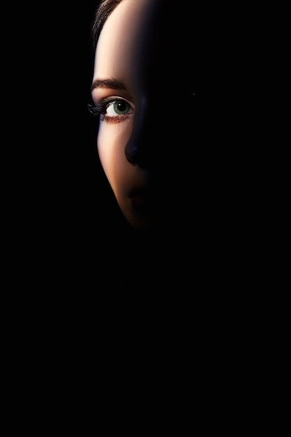 Piękna kobieta oko patrząc z ciemności
