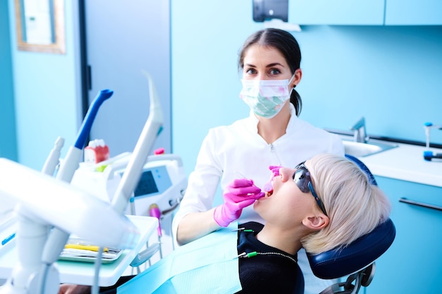 Piękna kobieta pacjentka poddawana leczeniu stomatologicznemu w gabinecie stomatologicznym Kobieta odwiedzająca swojego dentystę