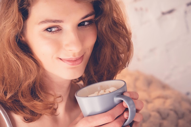Piękna kobieta pije kawę w swoim łóżku Koncepcja stylu życia