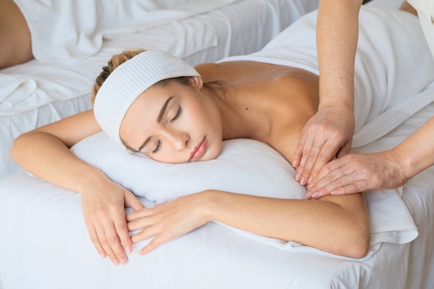 Piękna kobieta podczas masażu z olejkiem w pokoju spa