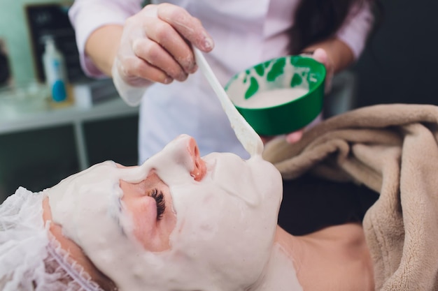 Zdjęcie piękna kobieta poddająca się kosmetycznemu oczyszczaniu twarzy od profesjonalnego dermatologa w spa wellness anti-aging skórze twarzy i luksusowej koncepcji stylu życia
