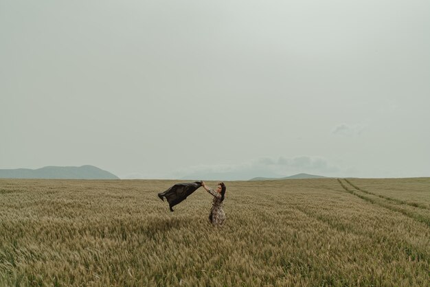 Zdjęcie piękna kobieta, pola pszenicy, wietrzny dzień