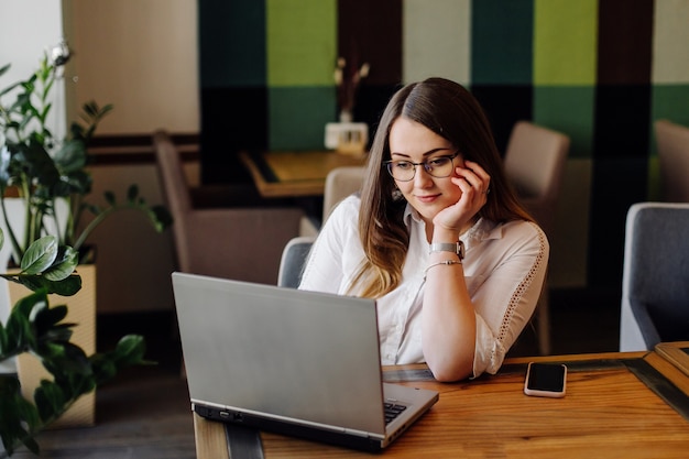 Piękna Kobieta Pracuje Na Swoim Laptopie I Telefonie W Stylowej Restauracji Miejskiej