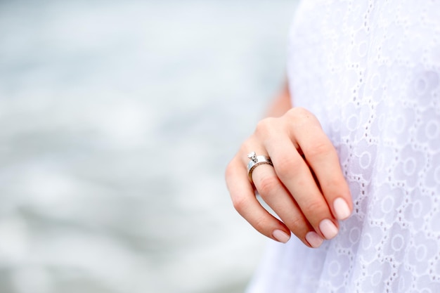 Piękna kobieta ręka z obrączką ślubną z tłem oceanu