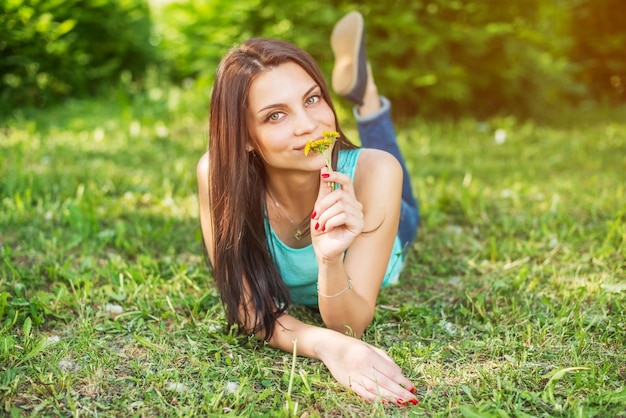 Piękna kobieta relaksuje się na świeżym powietrzu na trawie