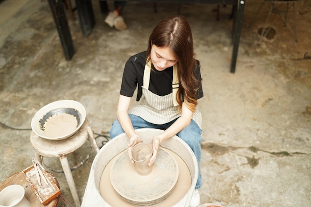 Piękna kobieta robi ceramikę ceramiczną na kole ręce zbliżenie kobieta w hobby freelance