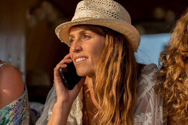 Piękna kobieta rozmawia z telefonem komórkowym podczas zachodu słońca