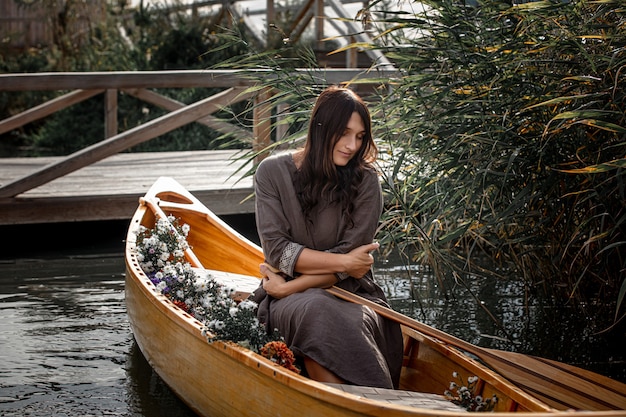 Piękna kobieta sama w drewnianej łódce pływającej po jeziorze prywatność z naturą