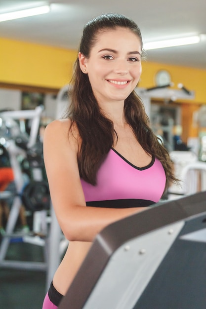 piękna kobieta sportowy uśmiechając się na bieżni na siłowni