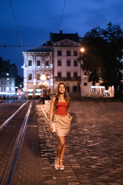 Piękna kobieta stojąca na placu starożytnego miasta wieczorem